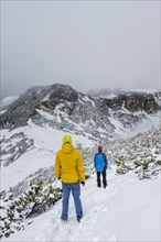 Two hikers on a hiking trail in the snow