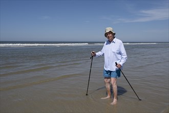 Older man walking on the beach