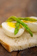 Boiled fresh green asparagus and eggs with extra virgin olive oil with rustic bread