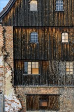 Charred wooden facade with brick wall