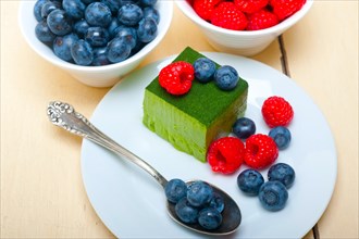 Green tea matcha mousse cake with raspberries and blueberries on top