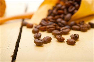 Espresso coffee beans on a paper cone cornucopia over white background