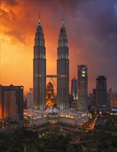 Petronas twin towers within tropical storm at colourful sunset
