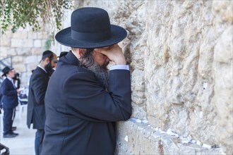 AJewish Orthodox man praying at the Western Wall
