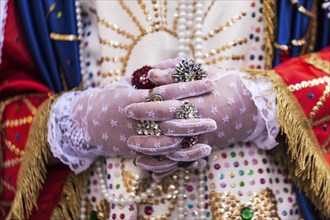 Detail of gloved hands and unique attire of the Veroniche during the Holy Thursday procession in Marsala