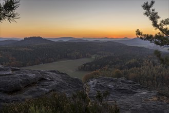 Rocks and vantage point on Pfaffenstein with view of Table Mountain Gohrisch at sunrise