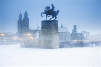 The equestrian Hans Waldmann Monument and the Fraumunster Church in the historical centre of Zurich during a snowstorm in Zurich