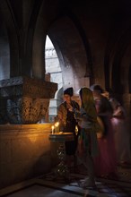 Believers lighting a candle at the Greek Orthodox Chapel inside the Crusader Church within the walls of ancient Jerusalem