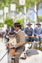 Detail of a man and his son on their horse during the week-long festivities of the Feria de Abril in Seville