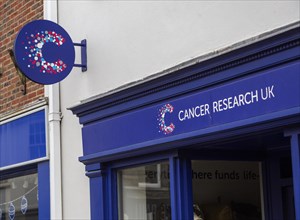 Cancer Research UK charity shop signs outside High Street store