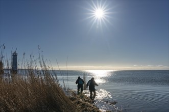 Two anglers in the backlight at the lighthouse of Maltzien on the island of Ruegen