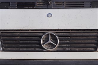Mercedes car logo on dirty radiator grille