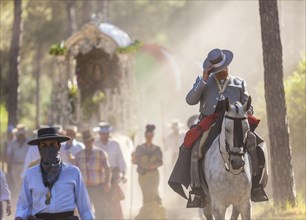 Pilgrims in traditional clothes on their way with the Simpecado and Carriages during the annual Romeria of E Rocio passing through the Donana National Park