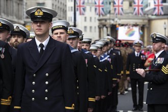 British navy participants enjoy the London Pride festival in brilliant sunshine under Union Jacks. London