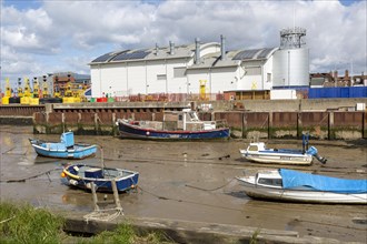 Boats at low tide in muddy creek by Trinity House