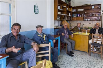 Elderly Greek men sitting in an improvised bar in the town of Kos