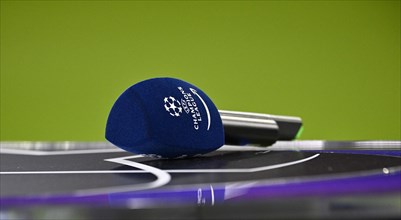 Microphone with Champions League logo lies on presenter's table