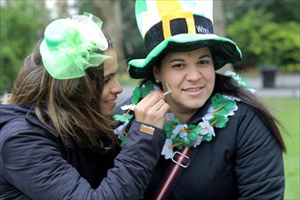 Two girls get ready for St. Patricks day in Dublin. St Stephens Green