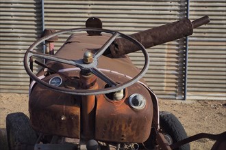 Rusty bonnet of tractor with steering wheel