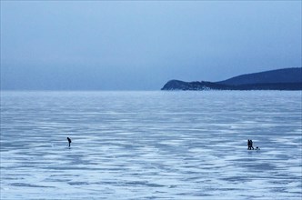 People dwarfed by their massive surroundings on Lake Baikal