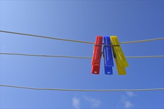 Clothesline with clothespins against blue sky