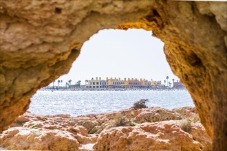 Beautiful sandstone arch with the view from Ferragudo to marina in Portimao