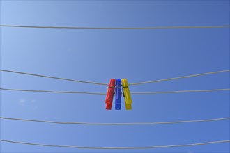 Clothesline with clothespins against blue sky