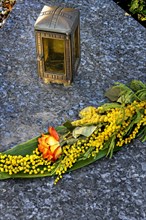 Grave slab with grave light and flower decoration