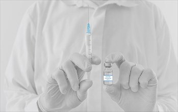 Doctor hands holding a vaccine bottle and syringe