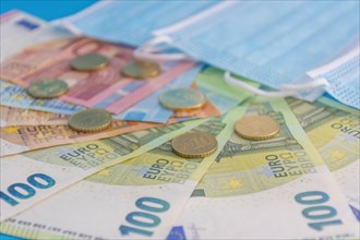 Medical masks and Euro banknotes. Financial crisis due to Coronavirus losses