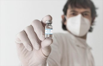 Doctor holding a vaccine bottle and syringe