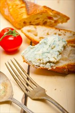 Fresh blue cheese spread ove french baguette with cherry tomatoes on side