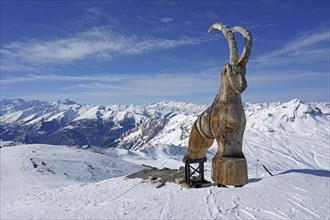 Wooden ibex figure, work of art, snow-capped mountains, La Masse peak, Trois 3 Vallees ski resort, Les Menuires, Haute Savoie, High Savoie, France, Europe