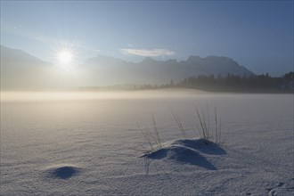 Frozen lake Barmsee with Karwendel mountainrange at sunrise in winter