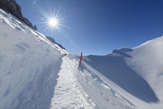 Path on Karwendelgrube Karwendel mountainrange with sun in winter