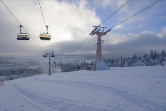 Chairlift in ski area and sun in winter