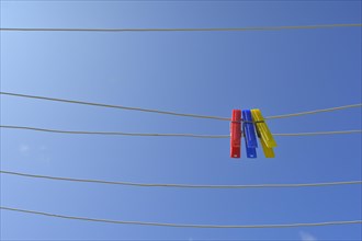 Clothesline with clothespins against blue sky