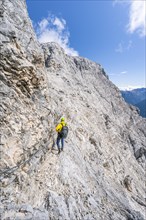 Climber on a via ferrata on a steep rock face