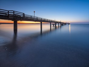 Pier on the beach of the Baltic Sea at dusk