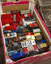 Box of old children's metal vehicles toys on display at auction