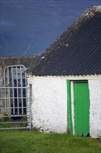 Green Irish door and white-washed wall near Wild Atlantic Way. County Kerry