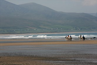 Horse-riding on the beach in beautiful seaside scene on Wild Atlantic Way. County Kerry