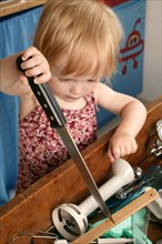 Toddler playing with a knife in the kitchen