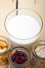Healthy breakfast ingredients milk oat cashew nuts dried cramberry craisinns