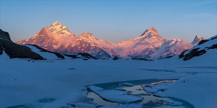 Evening light on the Bernese Alps with frozen Bachsee lake in the foreground