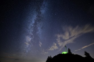 Green tent with summit cross under a starry sky on Portlakopf