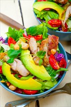 Fresh and healthy Chicken Avocado salad over rustic wood table