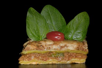Classic lasagne with spinach leaves and tomato