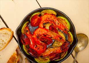 Roasted shrimps on cast iron skillet with zucchini and tomatoes