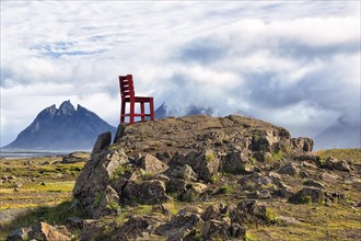 Red wooden chair on a rock